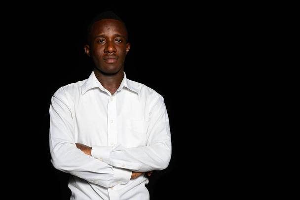 Portret młodego afrykańskiego biznesmena w ciemności na czarnym tle w nocy - Zdjęcie, obraz