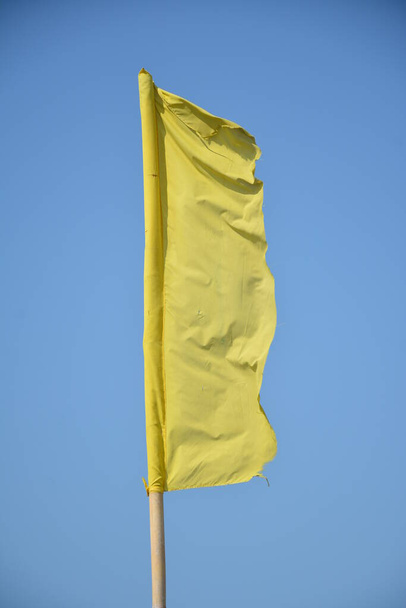 Tissu de bannière jaune avec poteau en bambou placé dans la plage pour bannière de signal - Photo, image