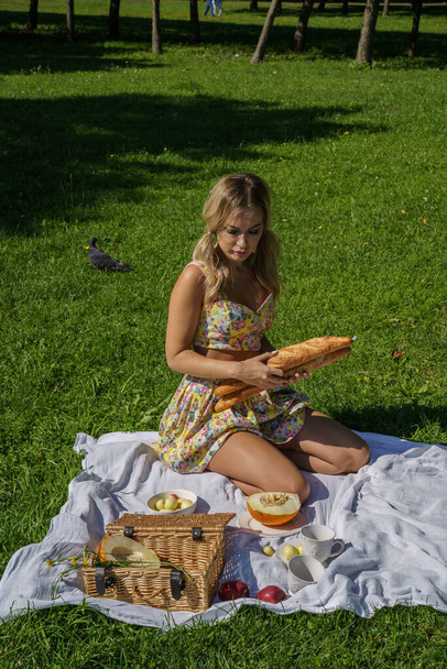 Outdoors portrait of beauty blond woman in summer clothes. Model resting on picnic at green park - Valokuva, kuva