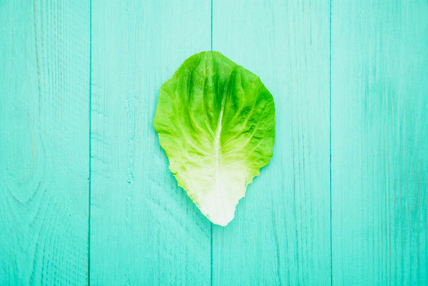 Fresh lettuce leaves on light background - Foto, afbeelding