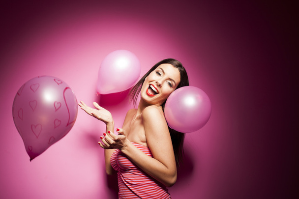 Beautiful woman with valentines day decorations on pink background - Fotó, kép