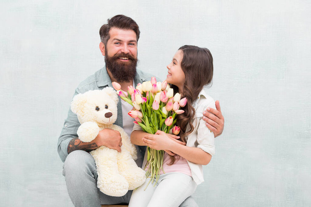 Wishing happy anniversary. Happy family celebrate anniversary. Father and daughter hold tulips and toy. Fathers day. Womens day. Birthday anniversary. Holiday celebration. International childrens day - Photo, Image