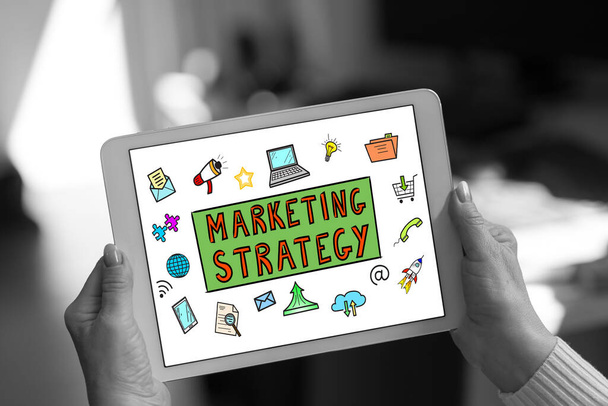 Conceito de estratégia de marketing mostrado em um tablet mantido por uma mulher - Foto, Imagem