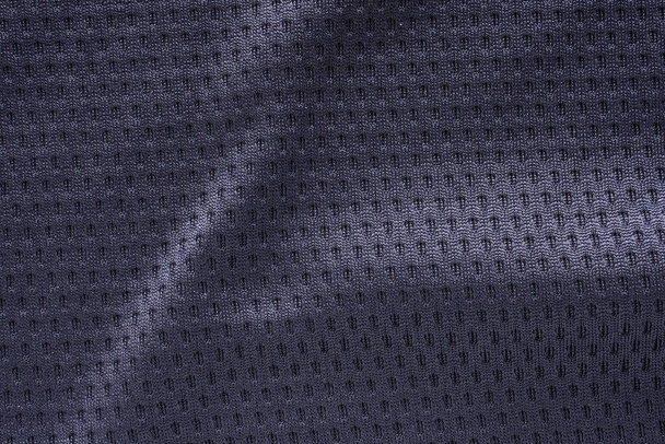 Camiseta de fútbol de ropa deportiva de tela negra con fondo de textura de malla de aire - Foto, imagen