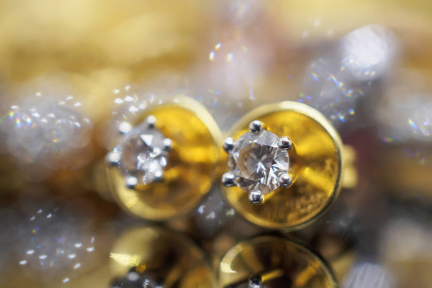 Luxusní zlaté šperky diamantové náušnice s odrazem na černém pozadí - Fotografie, Obrázek