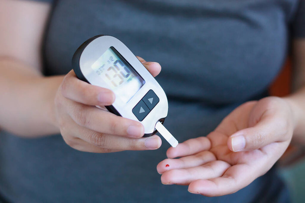 Test bloedglucose voor diabetes bij zwangere vrouw met glucometer - Foto, afbeelding