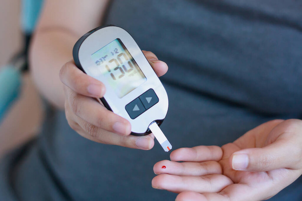 Teste de Glicose Sanguínea para Diabetes em Mulher Grávida com Glucometer
 - Foto, Imagem