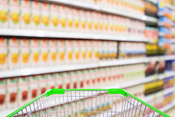 Supermarché avec des étagères de jus de fruits fond flou intérieur avec panier vide - Photo, image