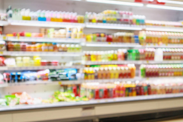 Estantes del refrigerador del supermercado con el producto del refresco del jugo de fruta fondo desenfoque abstracto - Foto, Imagen