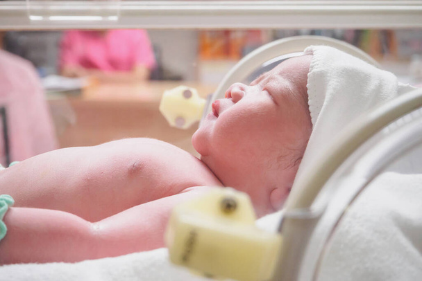 Neugeborenes Baby schläft im Brutkasten im Krankenhaus - Foto, Bild