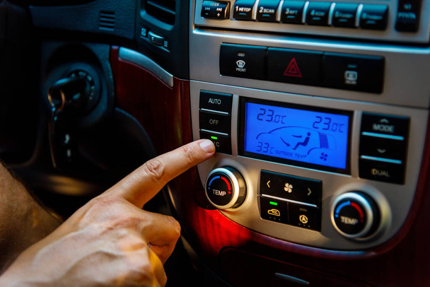 Zbliżenie mężczyzny uruchamiającego klimatyzator w nowoczesnym SUV-ie - Zdjęcie, obraz