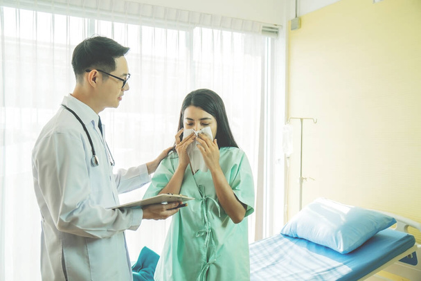 Hausarzt, der kranke Frau diagnostiziert, unglückliche Patientin, die ein Gewebe benutzt, um zu niesen und die Nase zu pusten und hohes Fieber durch Grippe und Erkältung zu bekommen, Patientenversorgung und Gesundheitsfürsorge. - Foto, Bild