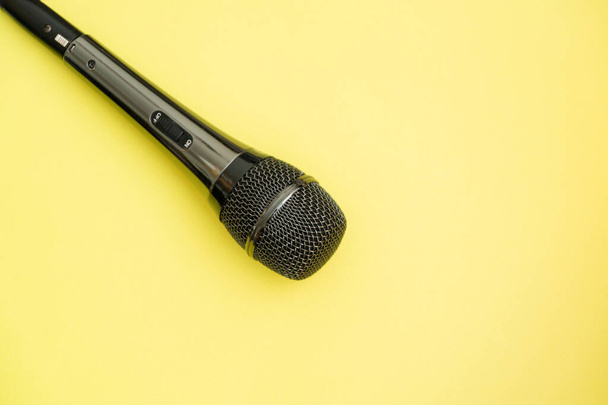 Micrófono gris sobre fondo amarillo con espacio para escribir - Foto, Imagen