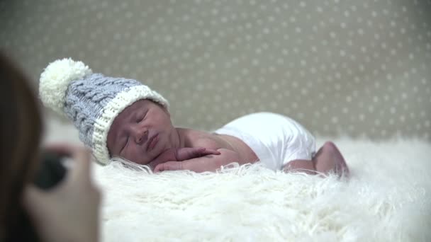 Baby liegt auf einer verschneiten simulierten Szene und wird fotografiert - Filmmaterial, Video