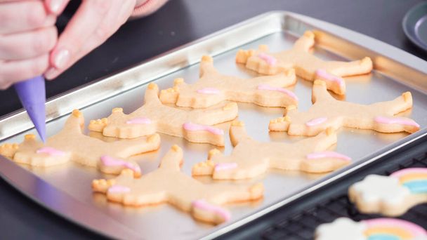 Pas à pas. Décorer les biscuits au sucre de licorne avec glaçage royal sur plaque à pâtisserie. - Photo, image