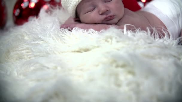 Bebé durmiendo ina escena de Navidad acostado en manta peluda blanca
 - Imágenes, Vídeo