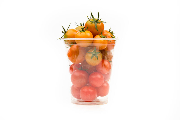 Cherry tomatoes in transparent plastic container on white background, close-up. - Foto, Imagem