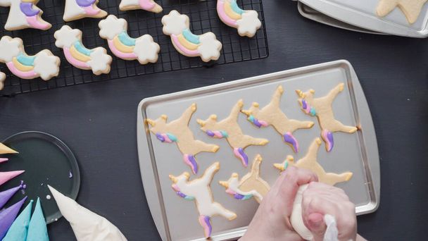 Paso a paso. Acostado. Decoración de galletas de azúcar unicornio con glaseado real en bandeja para hornear. - Foto, imagen