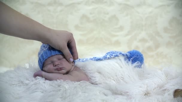 Mother holding baby's head while it sleeps on furry blanket - Footage, Video
