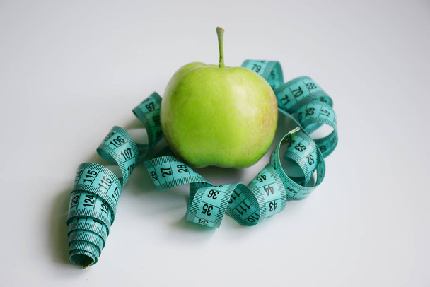 Concepto de plan de dieta con manzana verde y metro sobre fondo blanco aislado - Foto, imagen