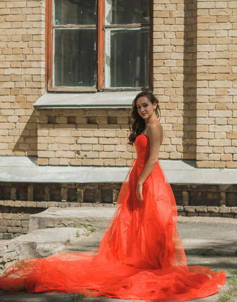 Βραδινά φορέματα έννοια, κομψό φανταχτερό στυλ. Γυναίκα με κόκκινο φόρεμα. Ρούχα για κυρίες, έμπνευση  - Φωτογραφία, εικόνα