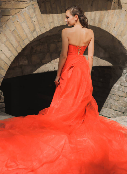 Estélyi ruhák koncepciója, elegáns divatos stílus. Esti vörös ruhás nő. Ruhák hölgyeknek, inspiráció  - Fotó, kép