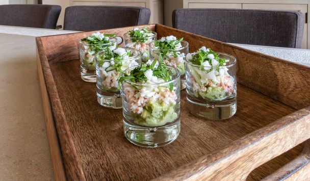 Festive appetizer glasses with avocado mousse and North Sea crab on a wooden tray. - Photo, Image
