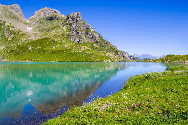 Alp Dağı gölü manzarası ve manzarası, mavi güzel ve şaşırtıcı göl manzarası, geniş açı mercek manzarası ve Svaneti, Georgia 'daki Okhrotskhali' de dağ yansımaları.. - Fotoğraf, Görsel