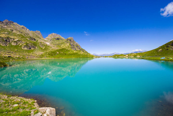 Alpesi hegyi tó táj és kilátás, kék gyönyörű és csodálatos tó panoráma, széles látószögű lencse táj és hegyi tükröződések Okhrotskhali Szvaneti, Georgia. - Fotó, kép