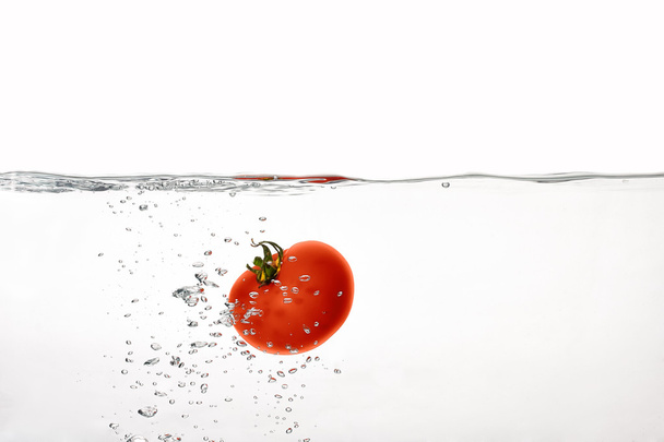 friss piros paradicsom, forrásban lévő vízben elszigetelt fehér background - Fotó, kép
