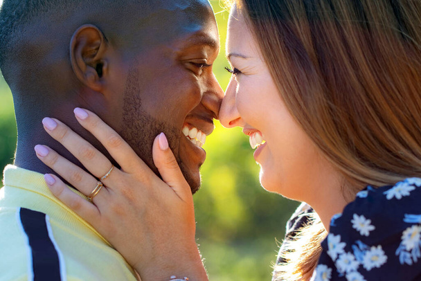 Close up ritratto all'aperto di multirazziale giovane coppia mostrando affetto all'aperto. nero ragazzo e bianco donna ridere. - Foto, immagini