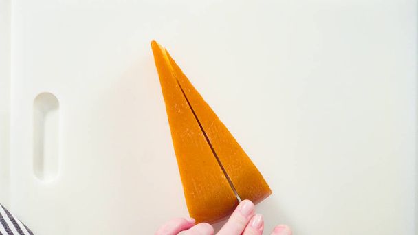 Flat lay. Slicing a large slice of gourmet cheese on a white background. - Photo, Image