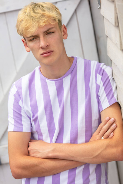 Boy teenager teen blonde male young man outside arms folded and wearing striped t-shirt - Фото, зображення