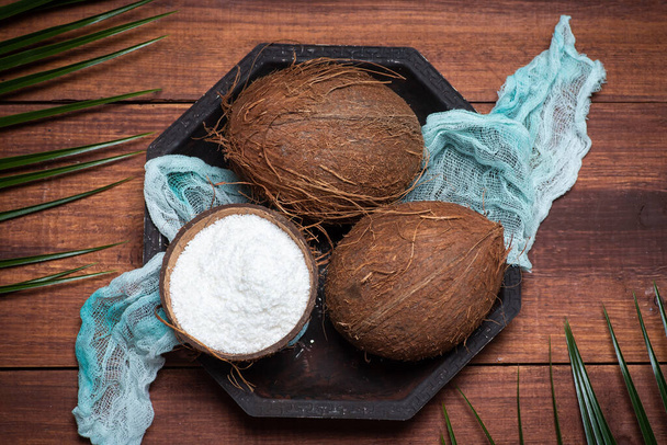 Open and grated coconut fruit on a wooden table top view - Photo, Image