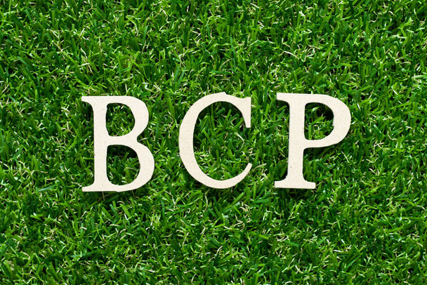 Wood alphabet letter in word BCP (abbreviation business continuity plan) on green grass background - Photo, Image