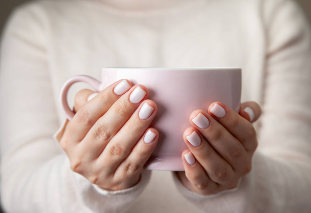 female hands holding a ceramic mug - 写真・画像