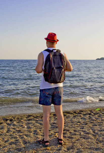 giovane in cappello rosso sulla spiaggia - Foto, immagini