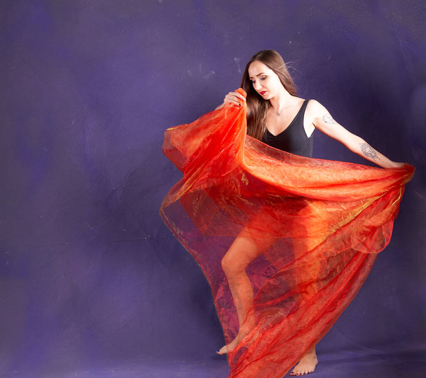 a white nice and fit girl, dancing with orange sash.                                         - Photo, Image