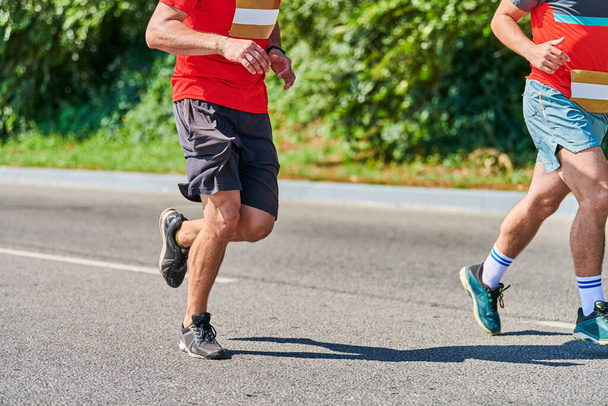 Running men. Sport men jogging in sportswear on city road. Healthy lifestyle, fitness hobby. Street marathon race, sprinting outdoor - Photo, Image