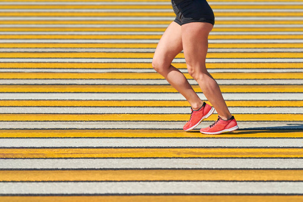 Woman running crosswalk, copy space. Athletic woman jogging in sportswear on city road. Healthy lifestyle, fitness sport hobby. Traffic violation. Street workout, sprinting outdoor - Φωτογραφία, εικόνα