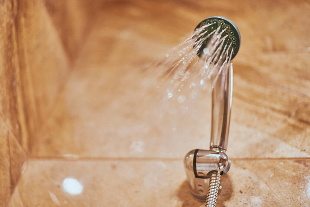 Showerhead in bathroom. Shower head with blurred hot water drops. Take a fresh contrast shower for sweat wash off - Photo, Image