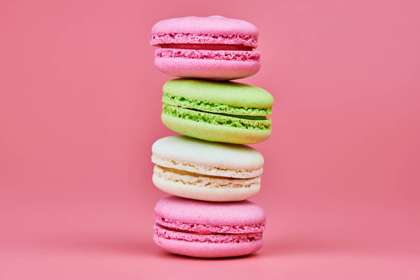 Macaroons on pink background. Colorful small cookie from ground almonds and coconut. Popular confectionery. Tasty snack food for take away, copy space - Foto, Imagen