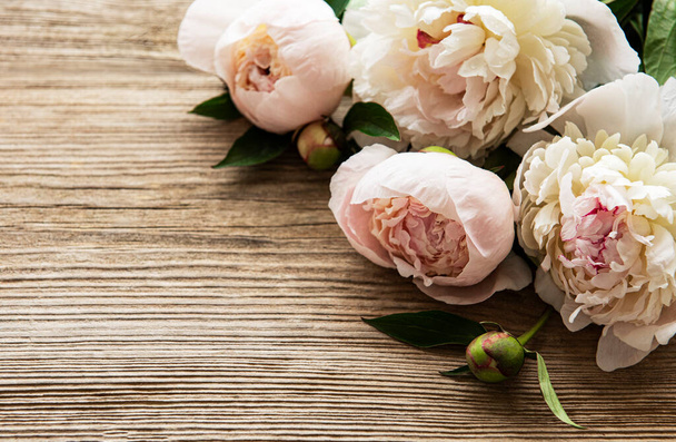 Pink peony flowers as a border on a old wooden background - Фото, изображение