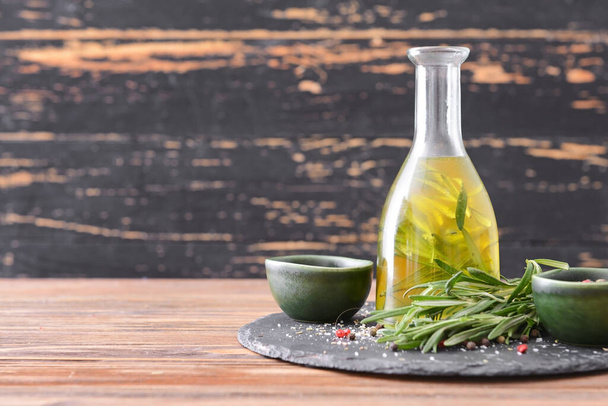 Bottle of rosemary oil and spices on table - Photo, Image