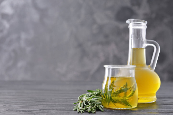 Bottle and jar of rosemary oil on table - Фото, зображення