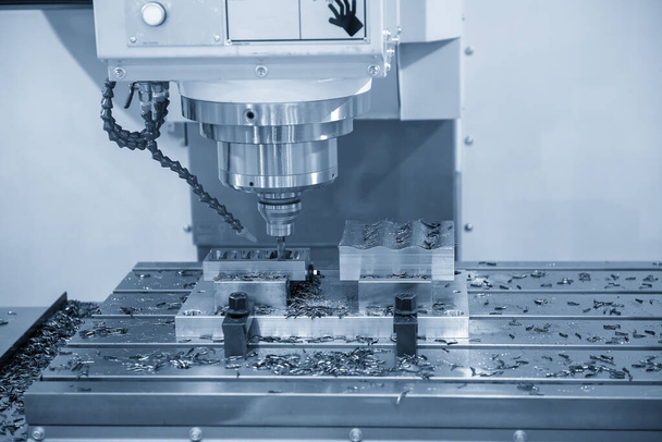 Η CNC μηχανή άλεσης που κόβει τα μέρη φορμών από το στερεό εργαλείο endmill. Η υψηλής ακρίβειας φόρμα και η έννοια κατασκευής κύβων από το κέντρο κατεργασίας.  - Φωτογραφία, εικόνα