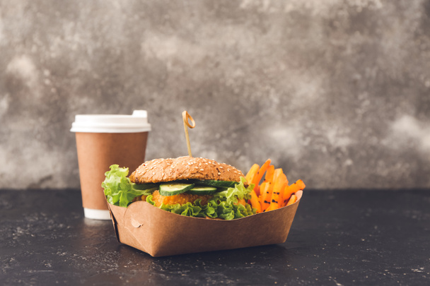 Chutný veganský burger s šálkem kávy na stole - Fotografie, Obrázek