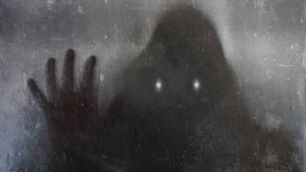 A ghostly hooded figure with glowing eyes. With a blurred, vintage, texture edit - Valokuva, kuva