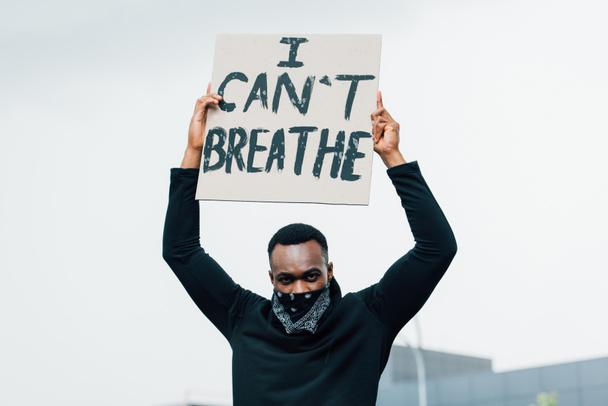 africký Američan se dívá na kameru a drží plakát s nemůžu dýchat nápisy venku  - Fotografie, Obrázek