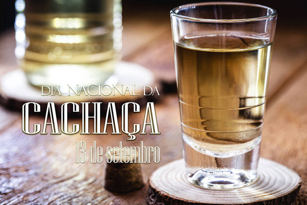 Стакан "качака", типичный напиток, дистиллированный из Бразилии, сделанный из сахарного тростника, также называемый "пинга", текст на португальском языке: 13 сентября национальный день качаа - Фото, изображение